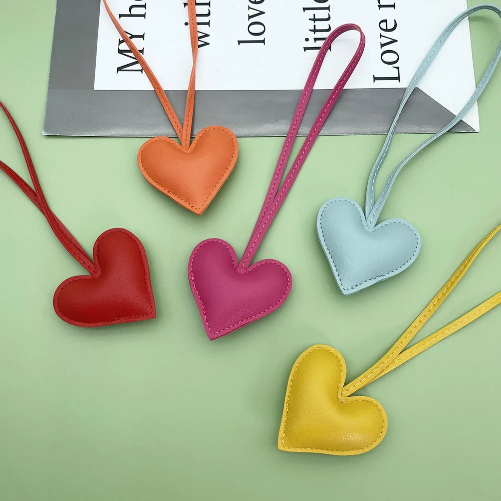 A collection of heart-shaped PU leather keychains in various colors, including orange, pink, red, blue, and yellow.