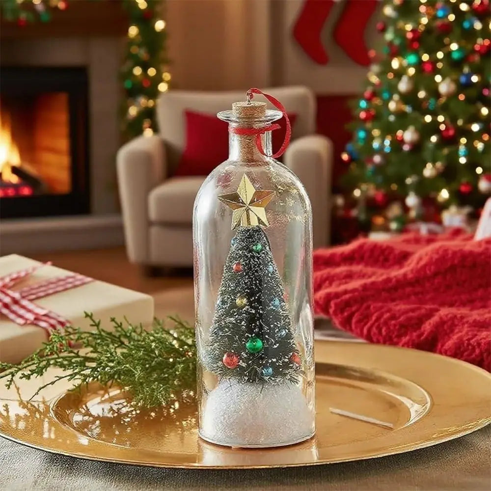 A glass message bottle shaped like a snowy Christmas tree is displayed on a gold plate near a decorated Christmas tree.