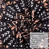 Black and white patterned tapestry fabric rolled up showing a repeating gothic design