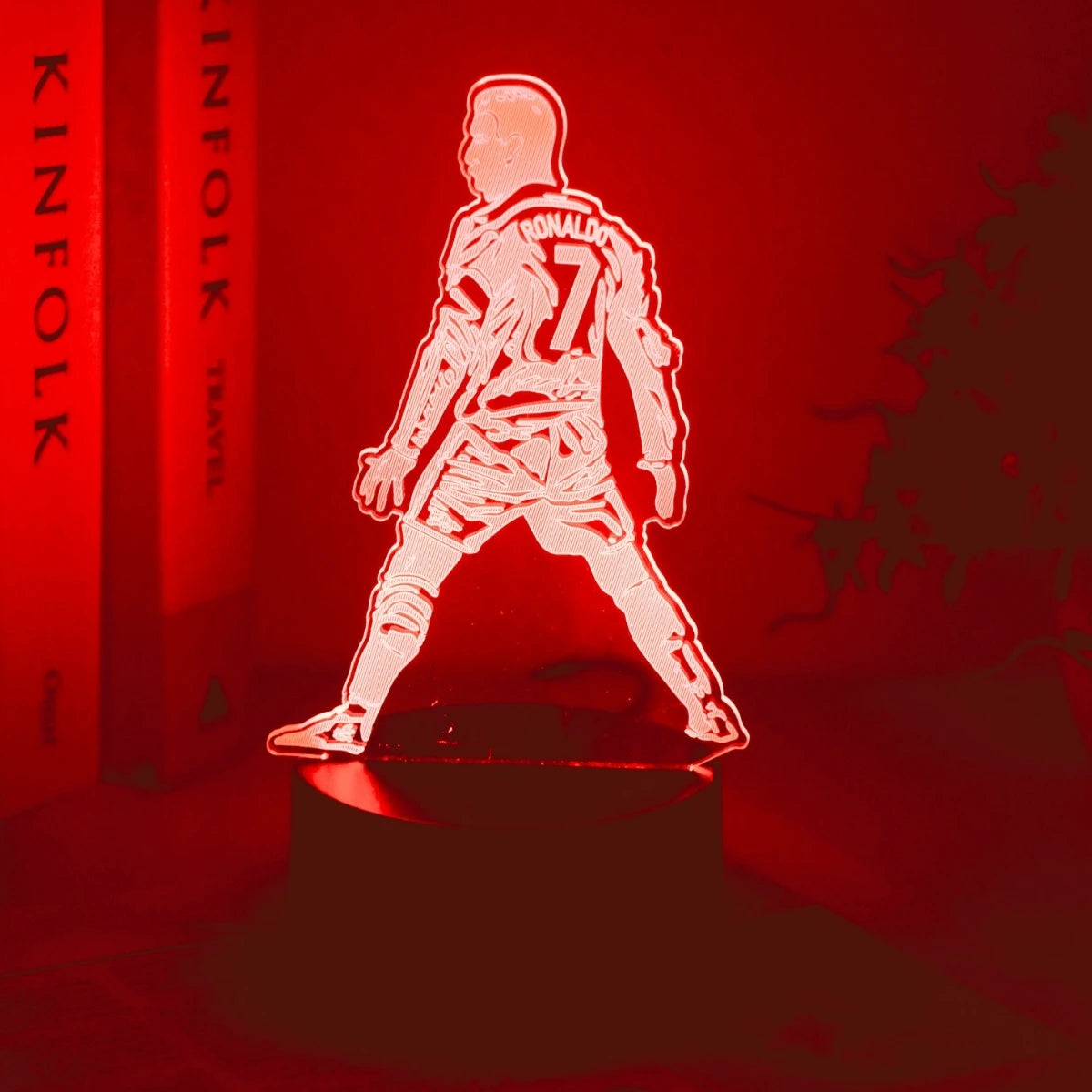 Leuchtend rote Silhouette eines Basketballspielers in einem Trikot steht auf einer dunklen Oberfläche.