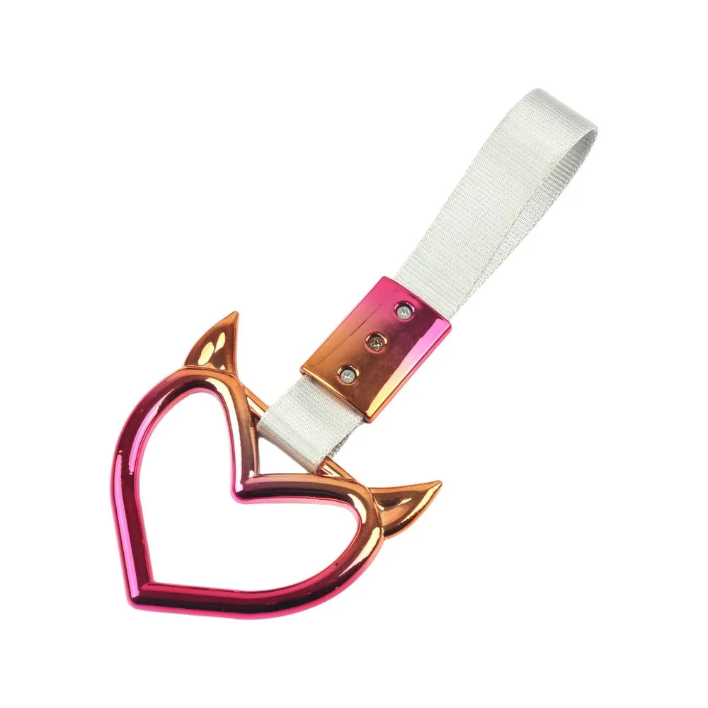 Heart-shaped car handle decor featuring a holographic finish and a white strap.