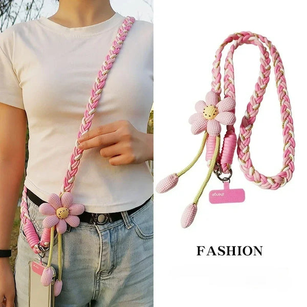 A pink decorative rope crossbody phone lanyard with a flower charm attached to a key ring.