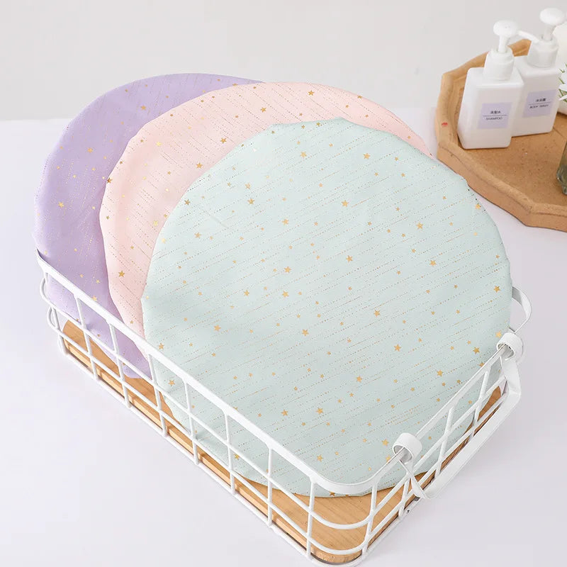 A white wire basket holds three reusable elastic shower caps in purple, pink, and light green.
