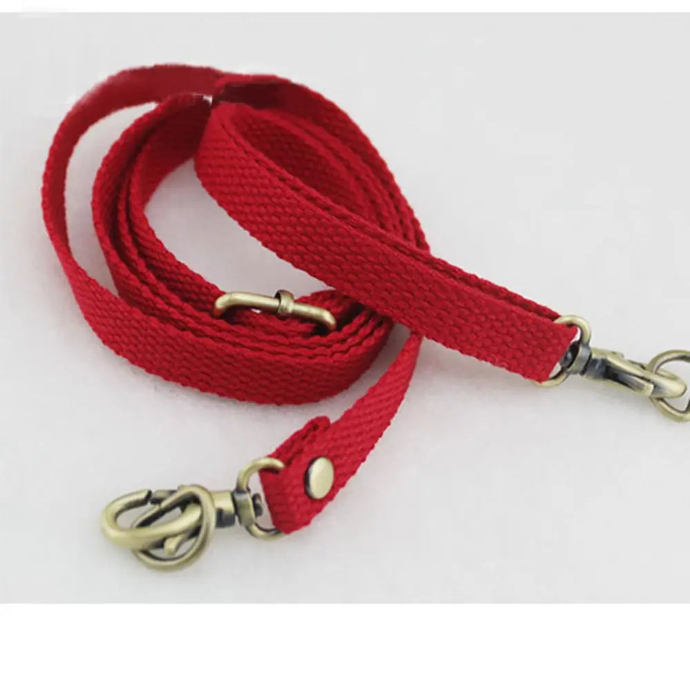 A red canvas shoulder strap with metal hardware is shown against a white background.