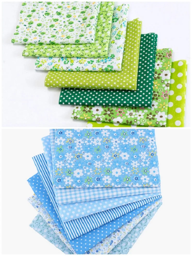 A stack of cotton fabric squares featuring various floral dot patterns in shades of green and blue.