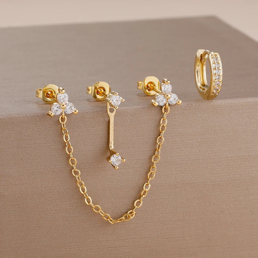 Boucles d'oreilles en chaîne dorée avec accents de zircon vert et une bague assortie.