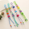 Ten alphabet letter beads in various colors and shapes strung on threads for DIY jewelry making