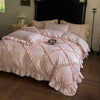 A pink ruffled duvet cover set with matching pillowcases displayed on a bed.