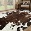 A dark brown and white cowhide print area rug in a modern western style placed in a living room.