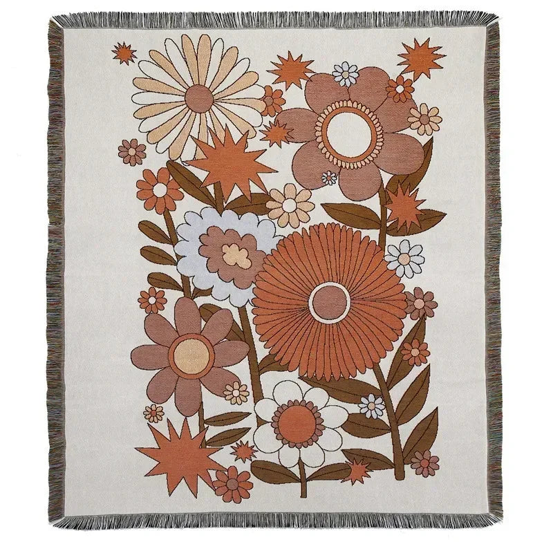 A woven throw blanket featuring a floral pattern in earthy tones of brown, orange, and beige on a cream background.