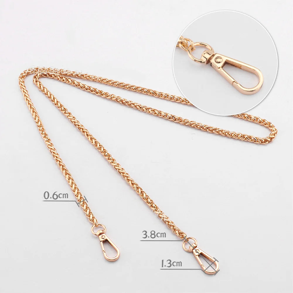 Gold-toned metal purse chain with adjustable buckles and a lobster clasp shown against a white background.
