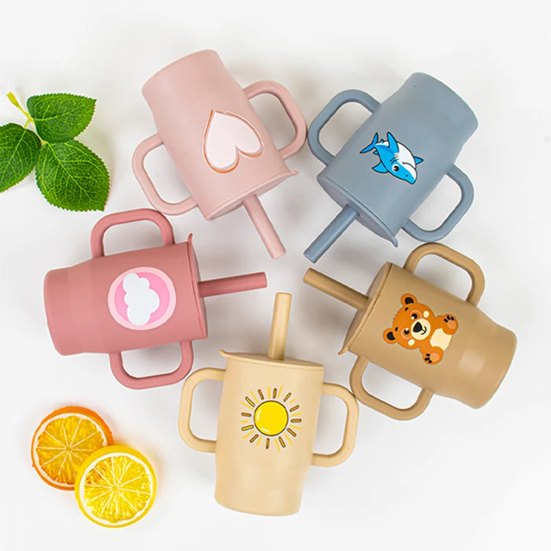 A collection of five silicone training cups with straws and handles in various pastel colors, including pink, blue, beige, an