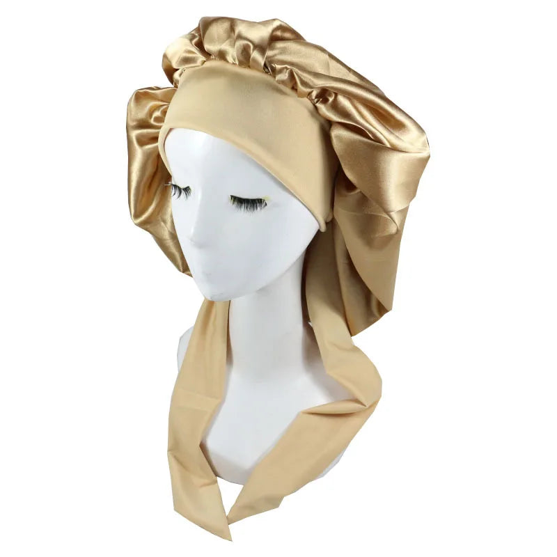 A golden satin sleep cap draped over a white mannequin head.