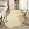 A cream colored irregular area rug with a plush soft texture placed on a light wood floor.