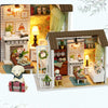 A miniature dollhouse kit featuring a wooden 3D puzzle craft with LED lights and detailed furniture.