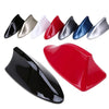A collection of various colored shark fin car antennas, including black, silver, white, and blue.