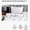 A white duvet insert and pillow set displayed on a bed, emphasizing quality craftsmanship and features like anti-drilling fab