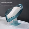 A blue self-draining soap dish with a white bar of soap is shown draining water into a sink.