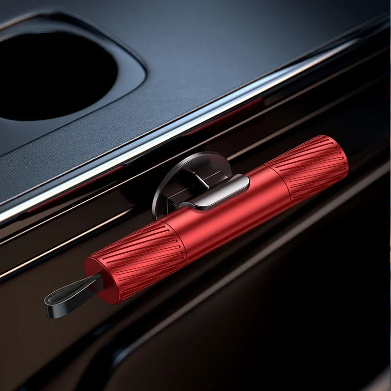 A close-up of a red emergency window breaker and seatbelt cutter tool resting on a dark surface.