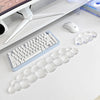 A set of clear, cloud-shaped ergonomic wrist rests for a keyboard and mouse are displayed on a white desk.