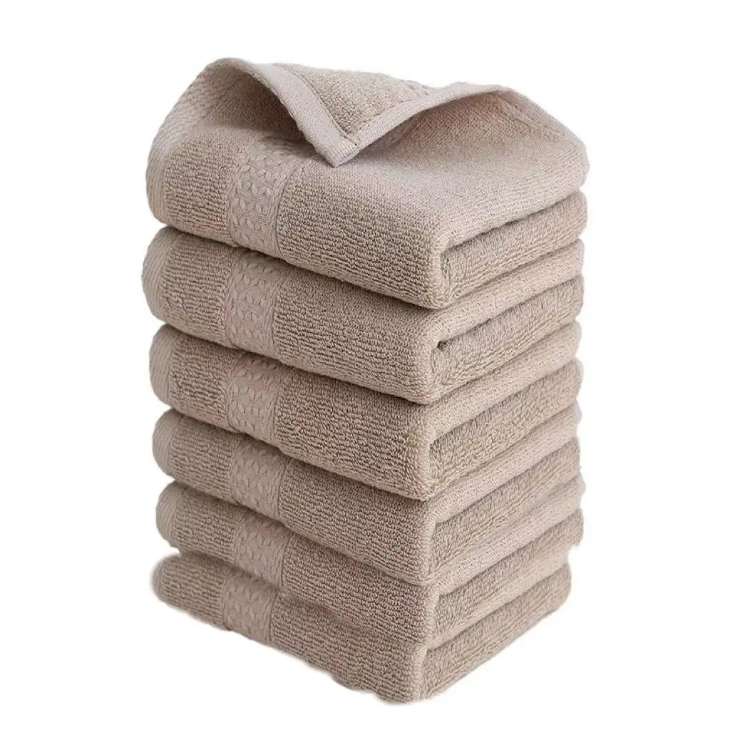 A stack of six beige premium pure cotton face towels folded neatly.