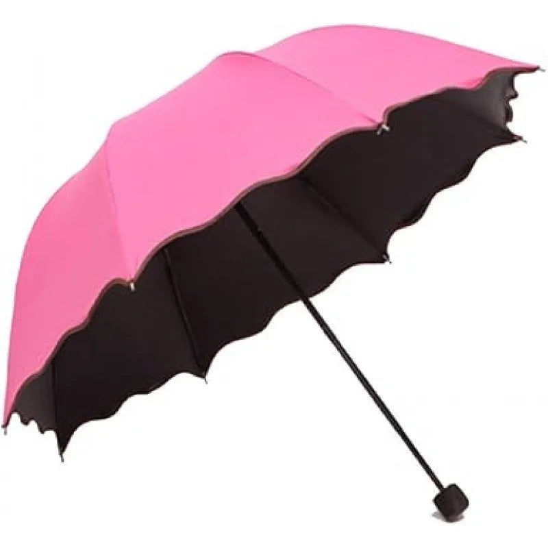 A pink and black floral bloom rain and sun umbrella open and angled against a white background.
