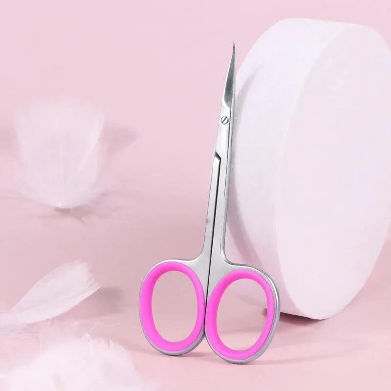 Pair of professional stainless steel cuticle scissors with curved blades on a pink background.
