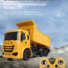 A yellow construction excavator dump truck and a remote control controller are shown against a cloudy sky.