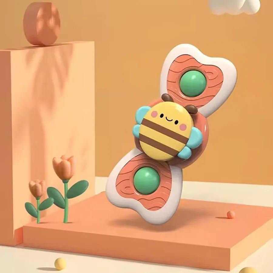 A cute, round bath toy shaped like a bee is shown on a wooden surface.
