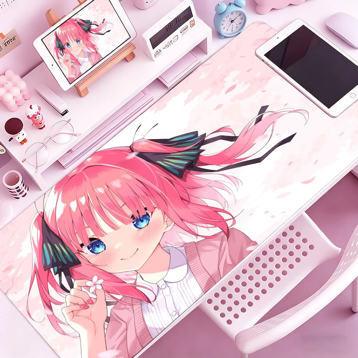 Anime girl illustration on a pink mouse pad featuring pink hair and blue eyes