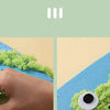 A hand is pressing green felt material onto a blue felt background to create a felt animal craft.