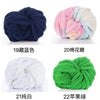 A collection of chunky acrylic yarn skeins in various colors including navy blue, pink, white, and green.