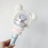 A white fluffy bear plush cover for a SEVENTEEN official light stick is held in a hand.