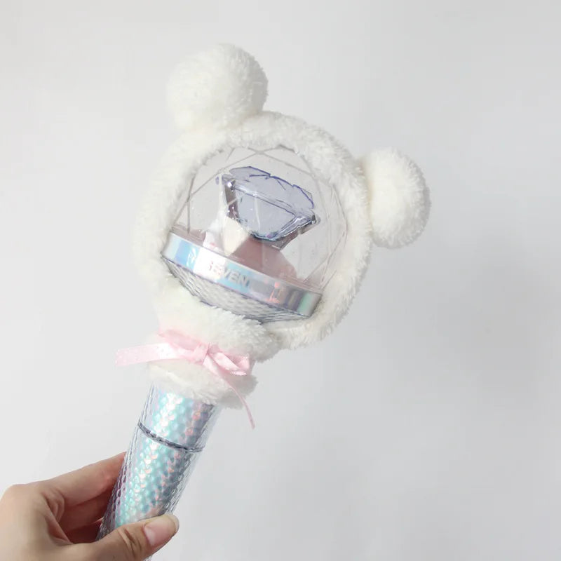 A white fluffy bear plush cover for a SEVENTEEN official light stick is held in a hand.