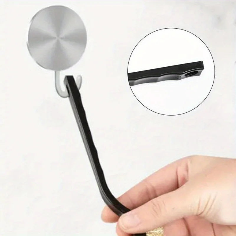 A hand holds a black kitchen cleaning brush with a silver scraper tool attached, shown next to an inset of the tools.