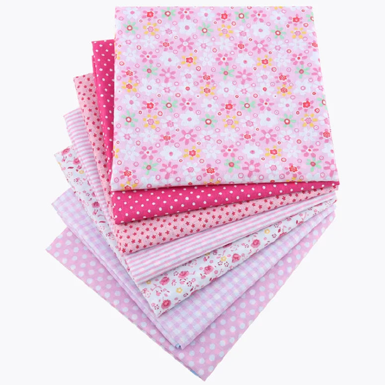 A bundle of pink and white floral dot patterned cotton fabric squares for patchwork and quilting.