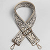 A beige and black paisley jacquard strap for a bag, featuring an X-shaped design and gold hardware.