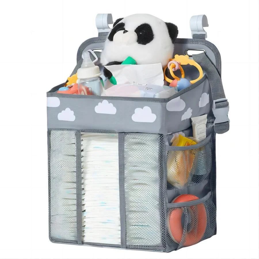 A gray hanging diaper storage organizer holding a panda toy and various diapers and accessories.