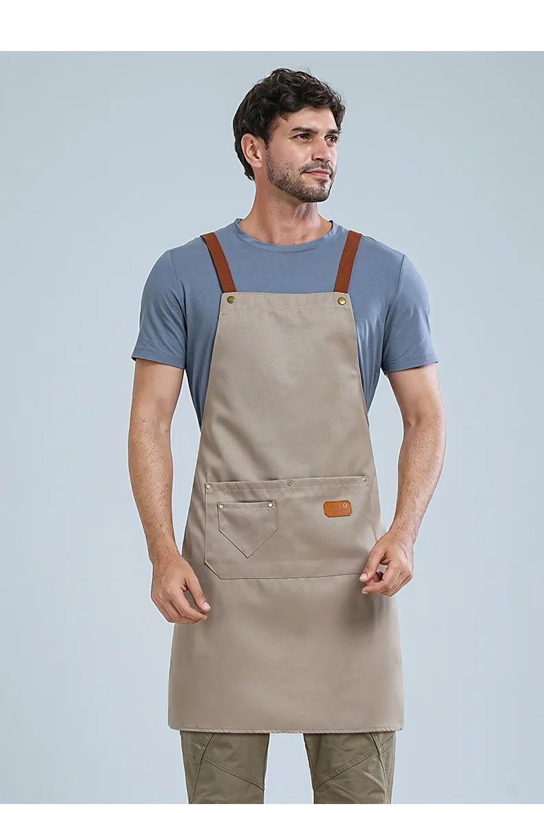 A man wearing a beige waterproof kitchen apron with brown straps and a gray t-shirt.