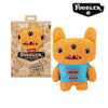 An orange Fuggler Ugly Monster plush toy with funny teeth wearing a blue shirt.