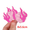 Pink cartoon cat embroidery patch for iron-on use shown being held by a hand