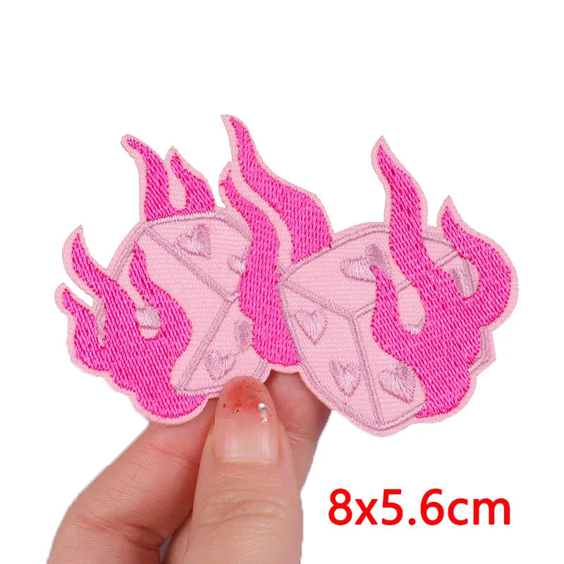 Pink cartoon cat embroidery patch for iron-on use shown being held by a hand