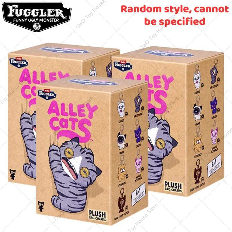 A box of Fuggler Alley Cats plush keychains featuring a purple and gray cat character.