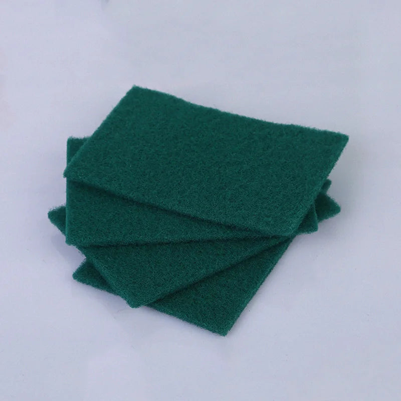 A stack of dark green microfiber kitchen scrub sponges for dishes and countertops.