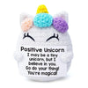 A handcrafted crochet unicorn doll with multicolored yarn horns and a smiling face.