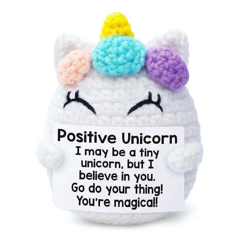 A handcrafted crochet unicorn doll with multi-colored yarn horns and a smiling face.