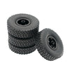 A stack of four black RC car upgrade wheels with metal rims and soft tires.
