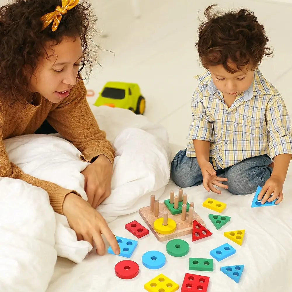 A child is sorting and stacking colorful wooden blocks on a white surface.