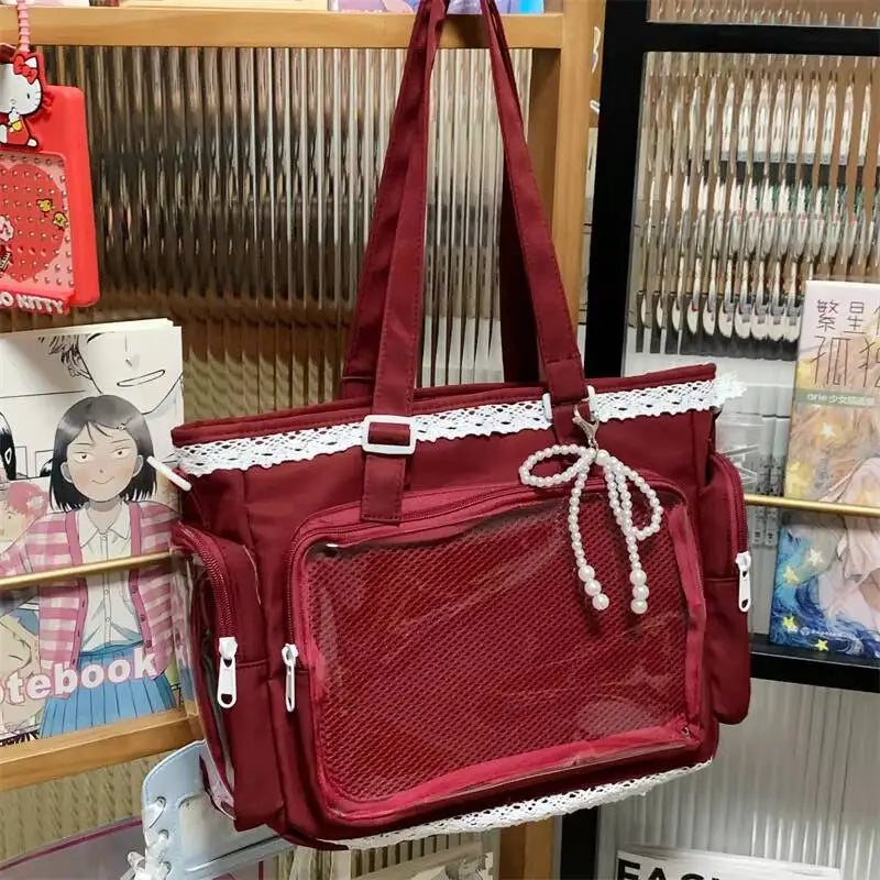 A maroon transparent shoulder bag with white lace trim hanging in a display rack.