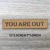 A brown woven patch with the text YOU ARE OUT on it, measuring 12x2.5cm or 4.7x1.0 inch.
